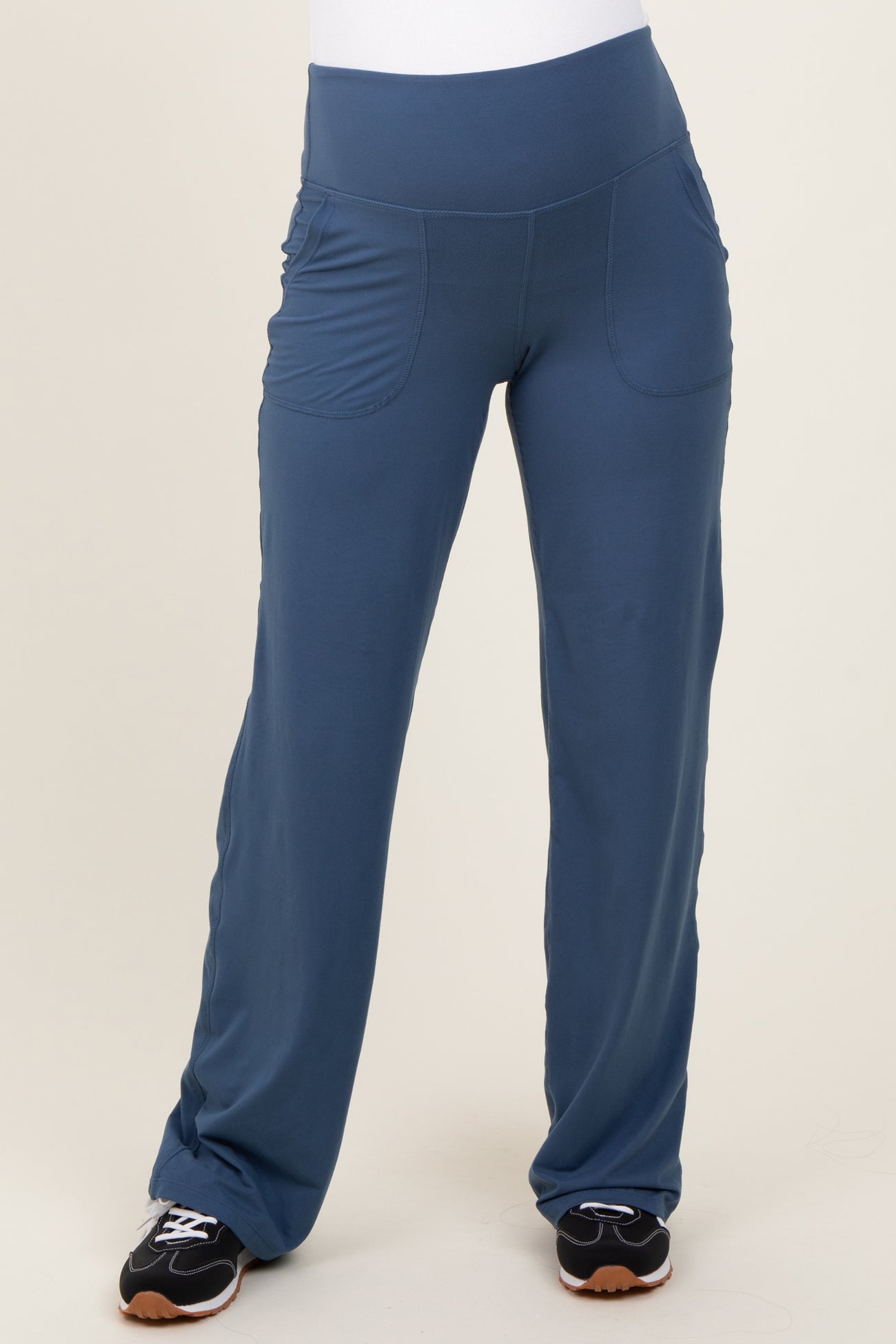 woman wearing blue maternity active pants with side pockets and a wide waistband