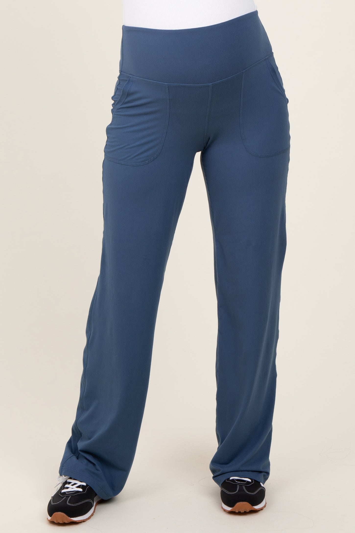 woman wearing blue maternity active pants with side pockets and a wide waistband