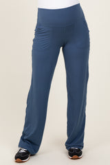 woman wearing blue maternity active pants with side pockets and a wide waistband