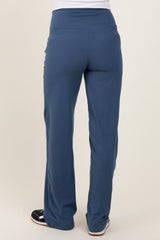 woman wearing navy blue maternity pants, view from the back, featuring a wide waistband and flared legs