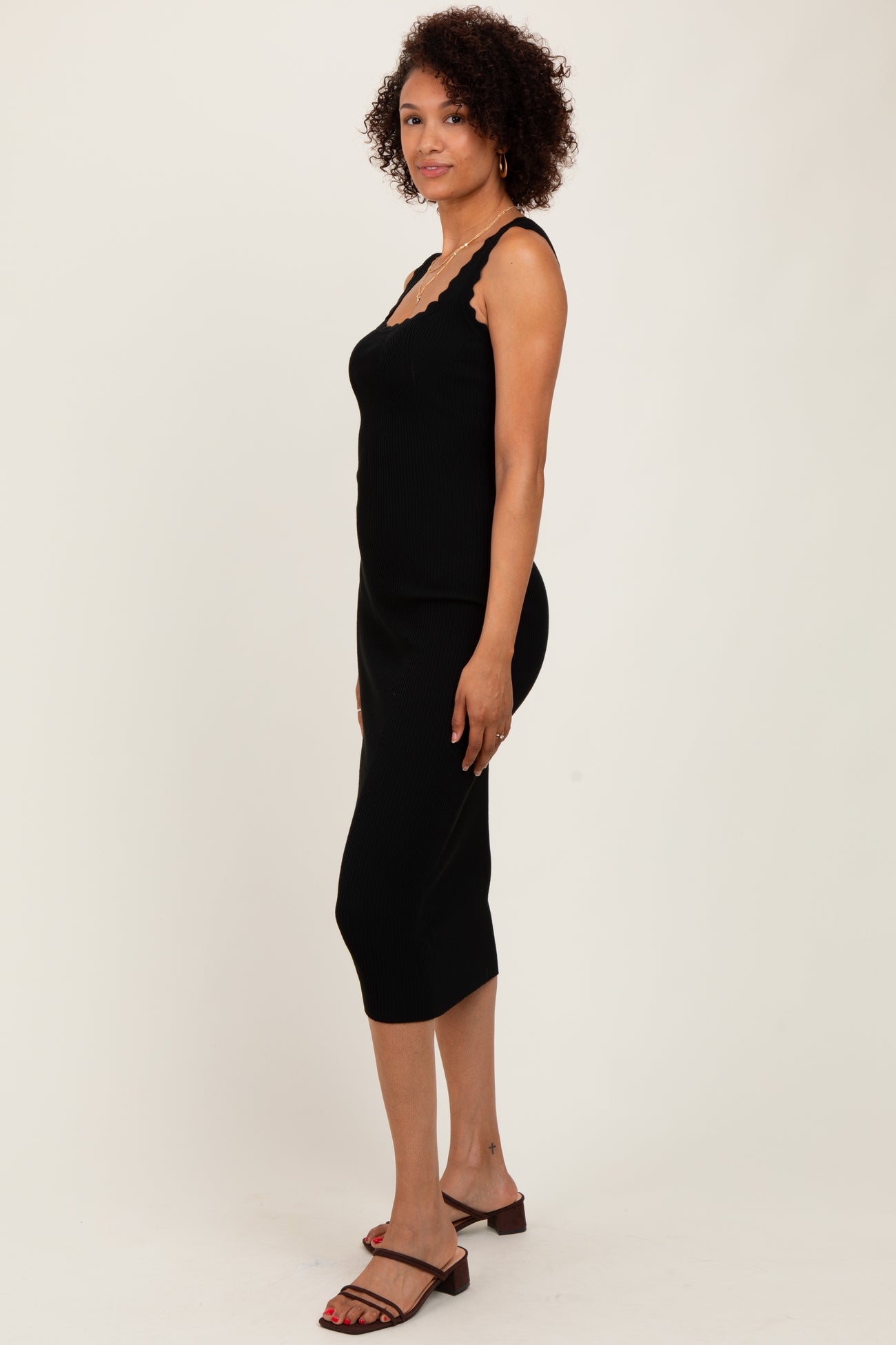 woman wearing a black ribbed midi dress with lace trim and adjustable straps