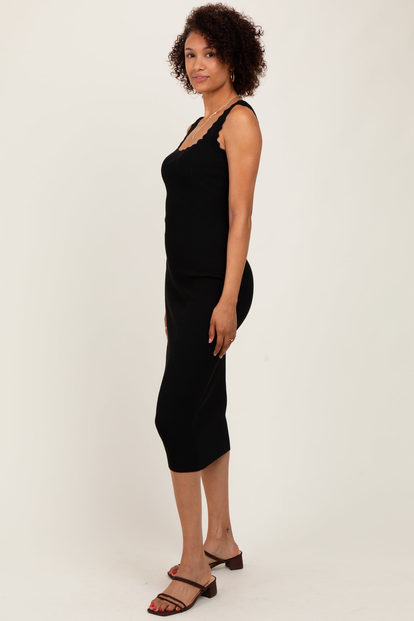 woman wearing a black ribbed midi dress with lace trim and adjustable straps
