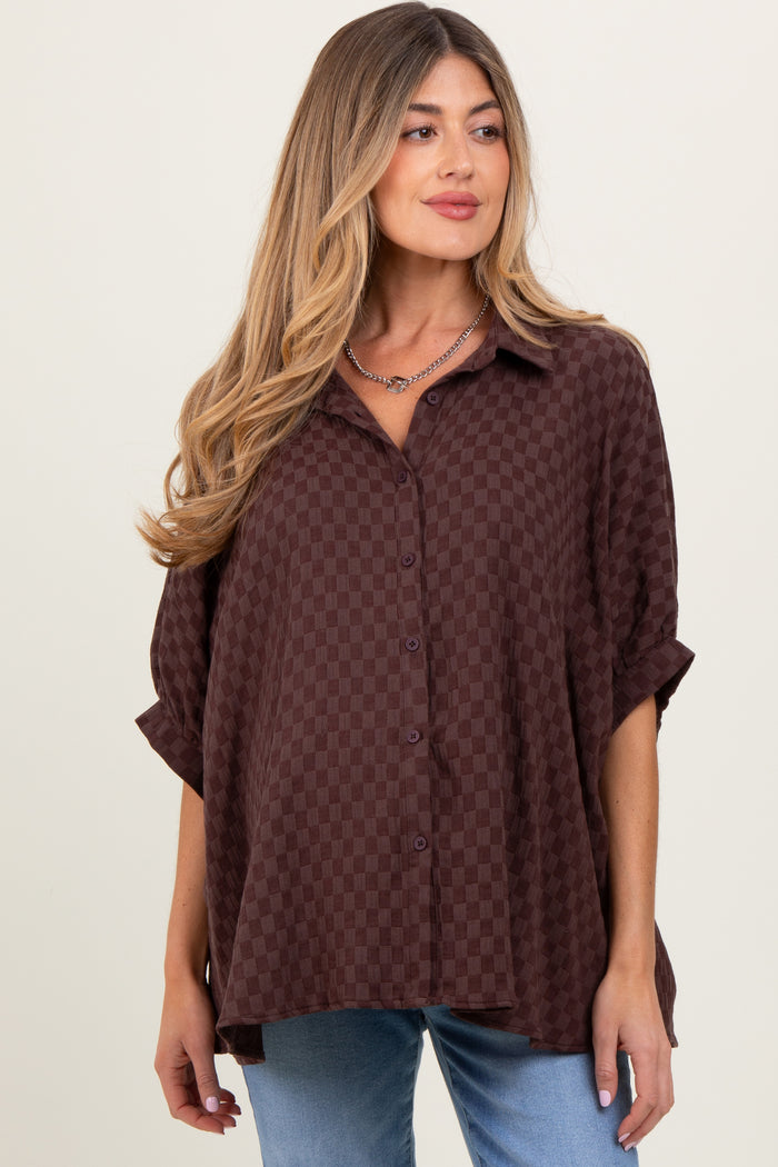 woman wearing a maroon checkered maternity shirt with rolled sleeves and a relaxed fit, showing her baby bump