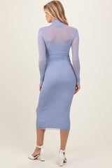 woman wearing a light blue maternity midi dress with long sleeves and a fitted silhouette, showing off her baby bump
