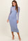 woman wearing a light blue fitted long sleeve dress with a high neckline and sheer overlay