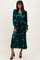 woman wearing a green velvet midi dress with floral embroidery and long sleeves