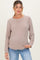 woman wearing a beige long sleeve maternity sweater with a relaxed fit and casual style