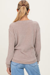 woman wearing a light brown maternity sweater with a relaxed fit and long sleeves, shown from the back