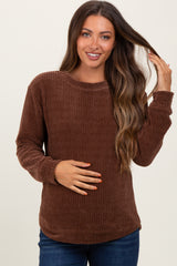 woman wearing a brown textured maternity top and showing her baby bump