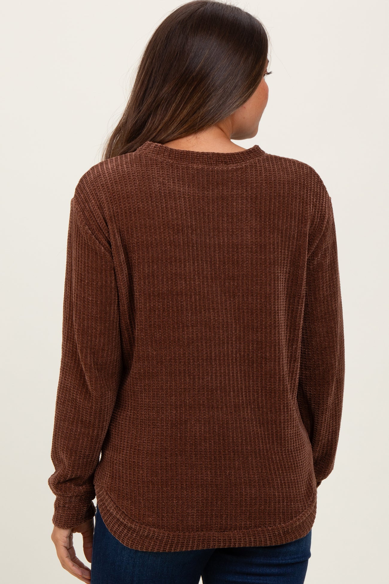 woman wearing a brown ribbed maternity sweater seen from the back