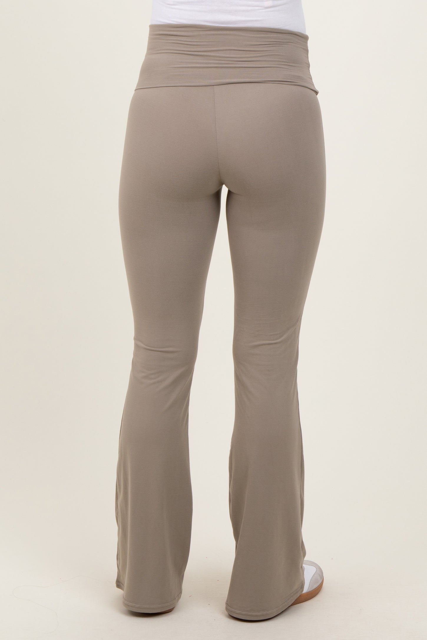 woman wearing light brown maternity flared leggings, showing the back view