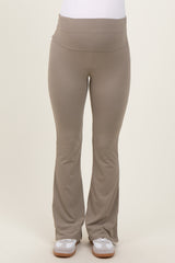 maternity wear in light taupe flared yoga pants with a wide waistband. model wearing the pants standing straight.