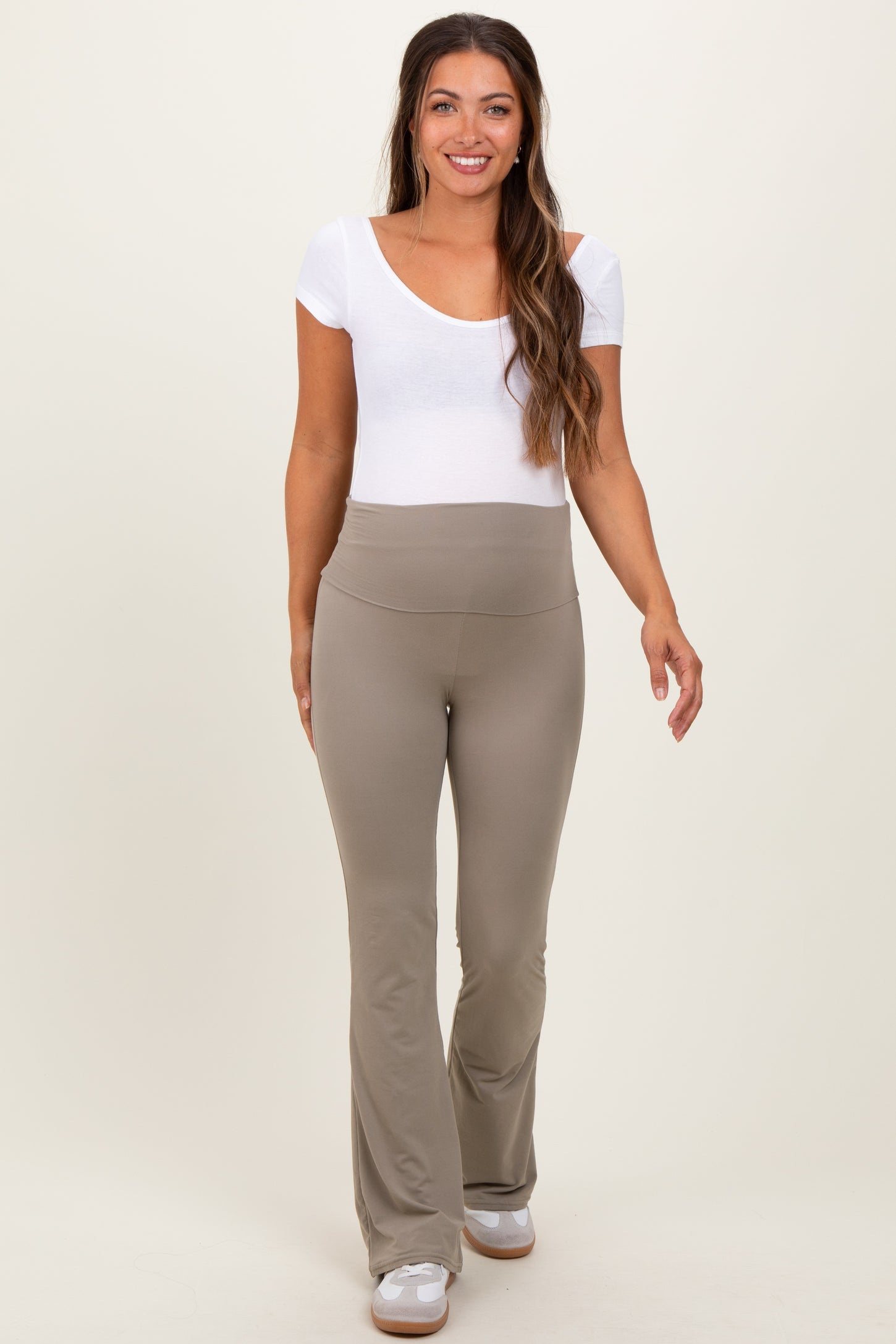 woman wearing a white short sleeve maternity top and beige flared maternity pants