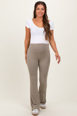 woman wearing a white short sleeve maternity top and beige flared maternity pants