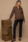 woman wearing a dark brown zip-up maternity sweater and black maternity pants, posing with wooden crates