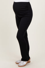 woman wearing black maternity leggings, highlighting her baby bump, paired with casual slip-on shoes