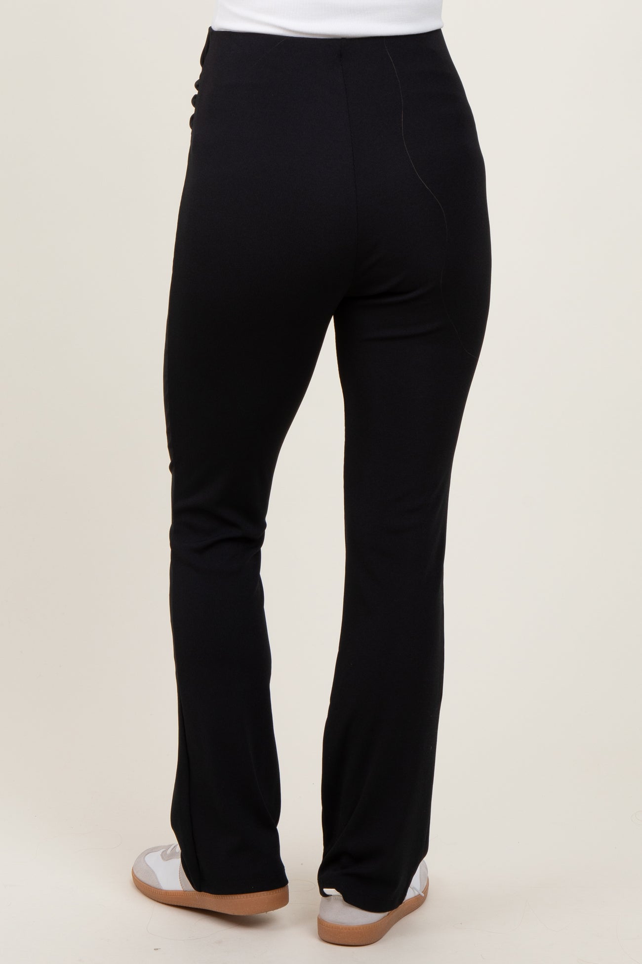 woman wearing black maternity pants from the back, featuring a comfortable fit and slight flare at the hem