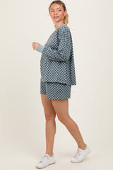 woman wearing a blue checkered loungewear set with long sleeve top and shorts, styled with white sneakers