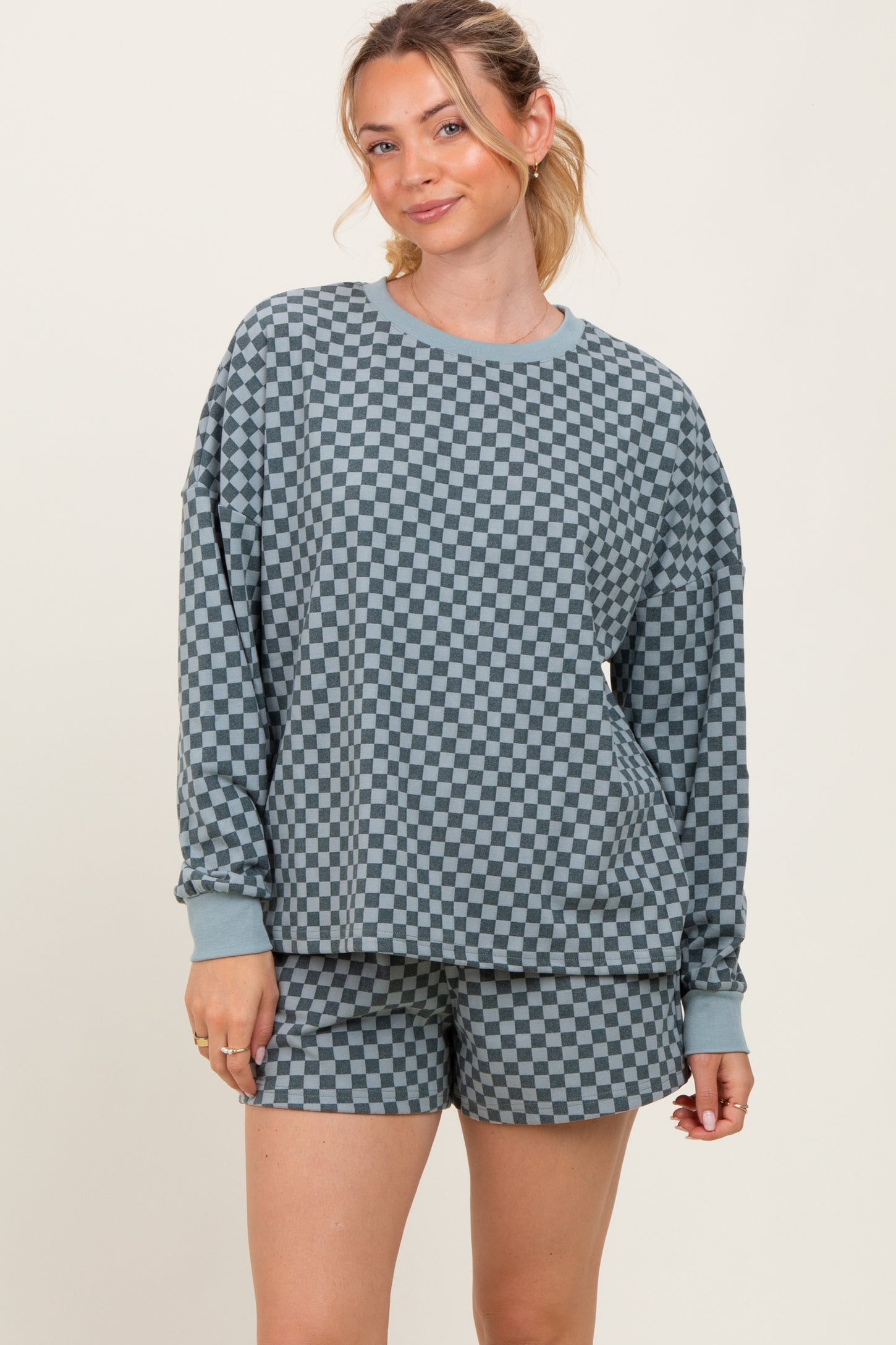 woman wearing a blue and gray checkered long sleeve sweatshirt and matching shorts