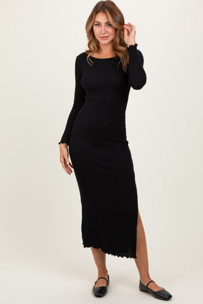 woman wearing a black long sleeve ribbed maxi dress with a side slit and scalloped hem