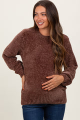 woman wearing a brown textured maternity sweater and holding her baby bump