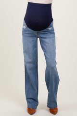 woman wearing distressed light blue maternity jeans with a dark navy over-the-bump waistband