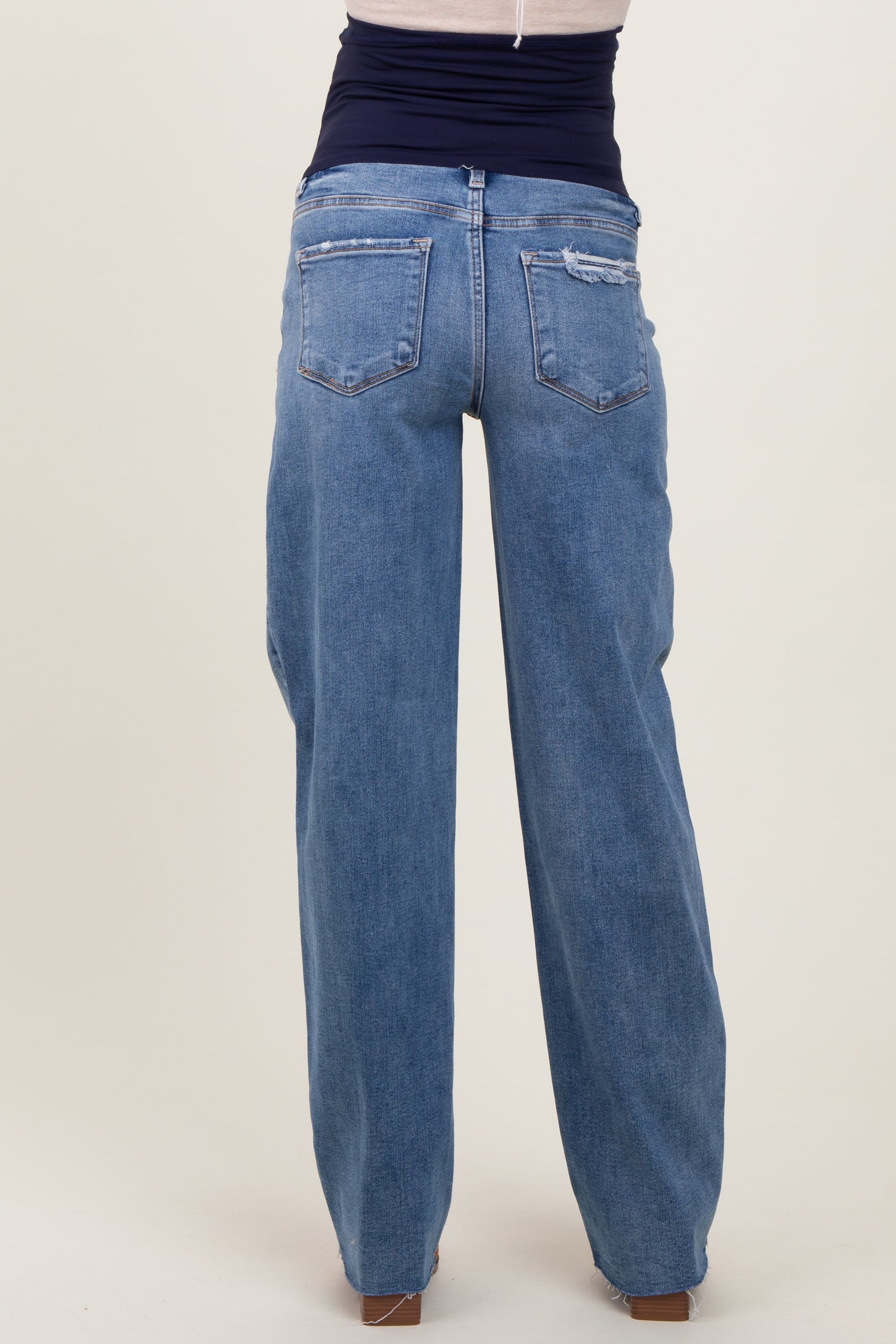 woman wearing light blue maternity wide-leg jeans, view from the back showing the relaxed fit and pocket details