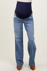 woman wearing distressed light blue maternity jeans with a dark navy over-the-bump waistband