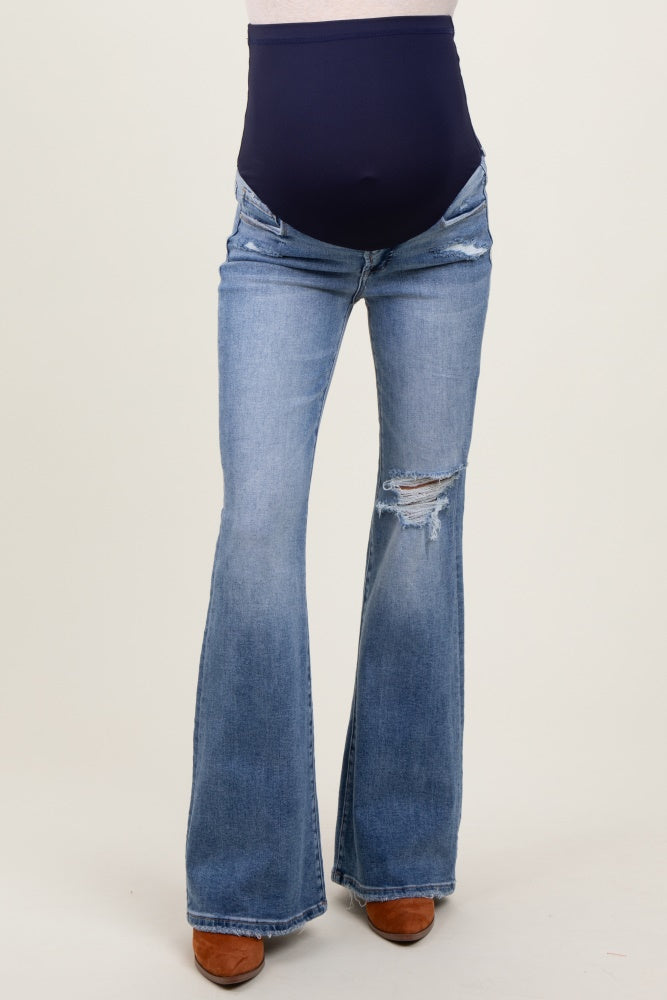 maternity wear blue flared jeans with a dark blue over-the-bump waistband and distressed detailing on the legs