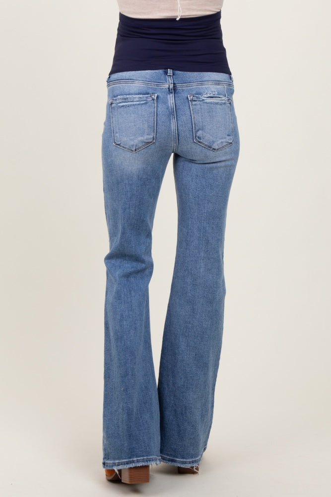 woman wearing a pair of light blue maternity flared jeans, showing the back view with a smooth waistband