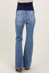 woman wearing a pair of light blue maternity flared jeans, showing the back view with a smooth waistband