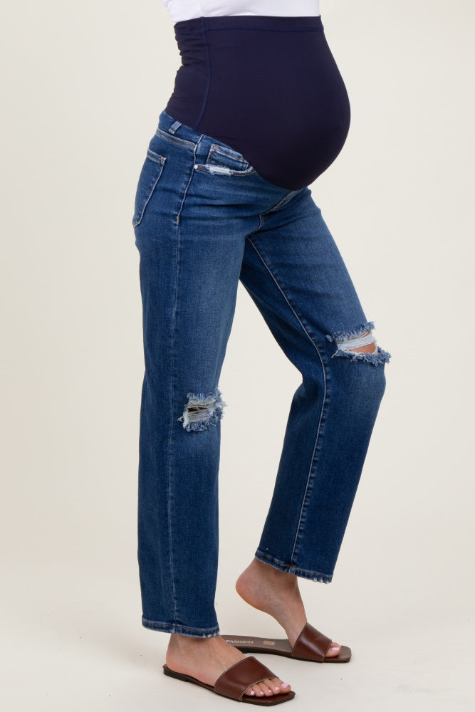 woman wearing a pair of distressed blue maternity jeans with a navy belly panel and a visible baby bump