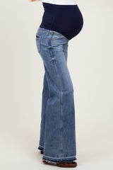 woman wearing maternity flared jeans with a dark blue over-the-bump panel and visible baby bump