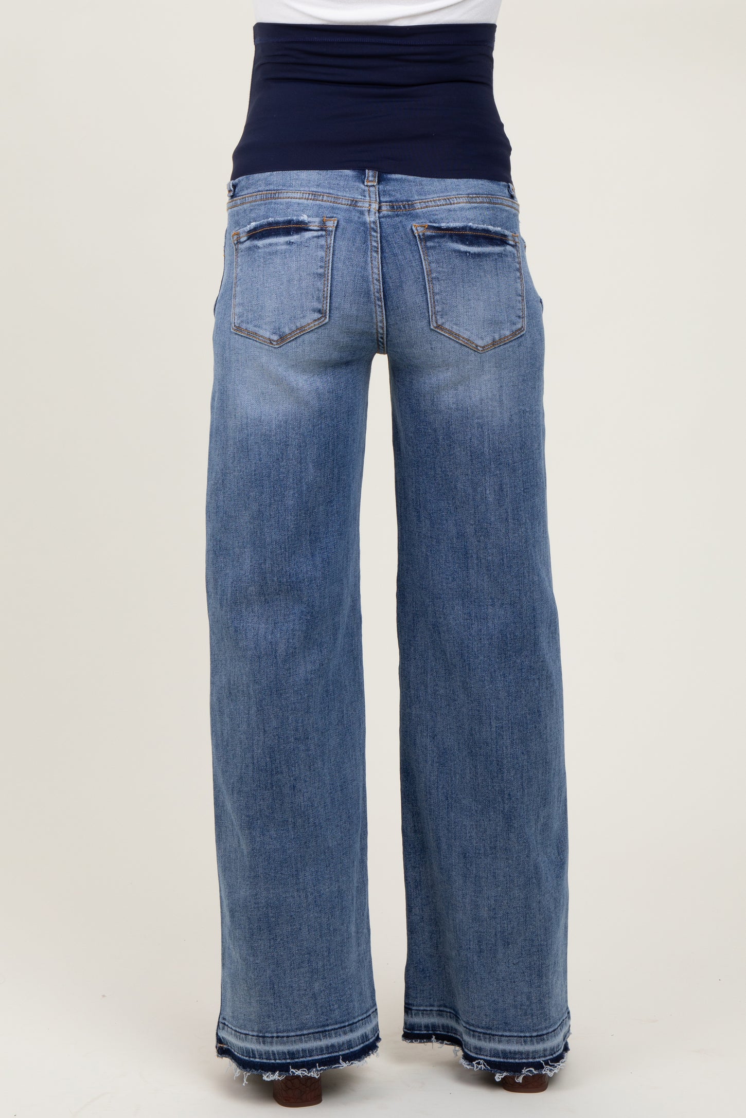 maternity wear light blue wide leg jeans with a dark blue support band, shown from the back