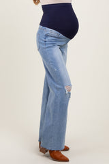 woman wearing light blue maternity flared jeans with a navy belly band and visible baby bump