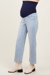 woman wearing light blue maternity jeans with a dark blue belly band and beige ankle boots