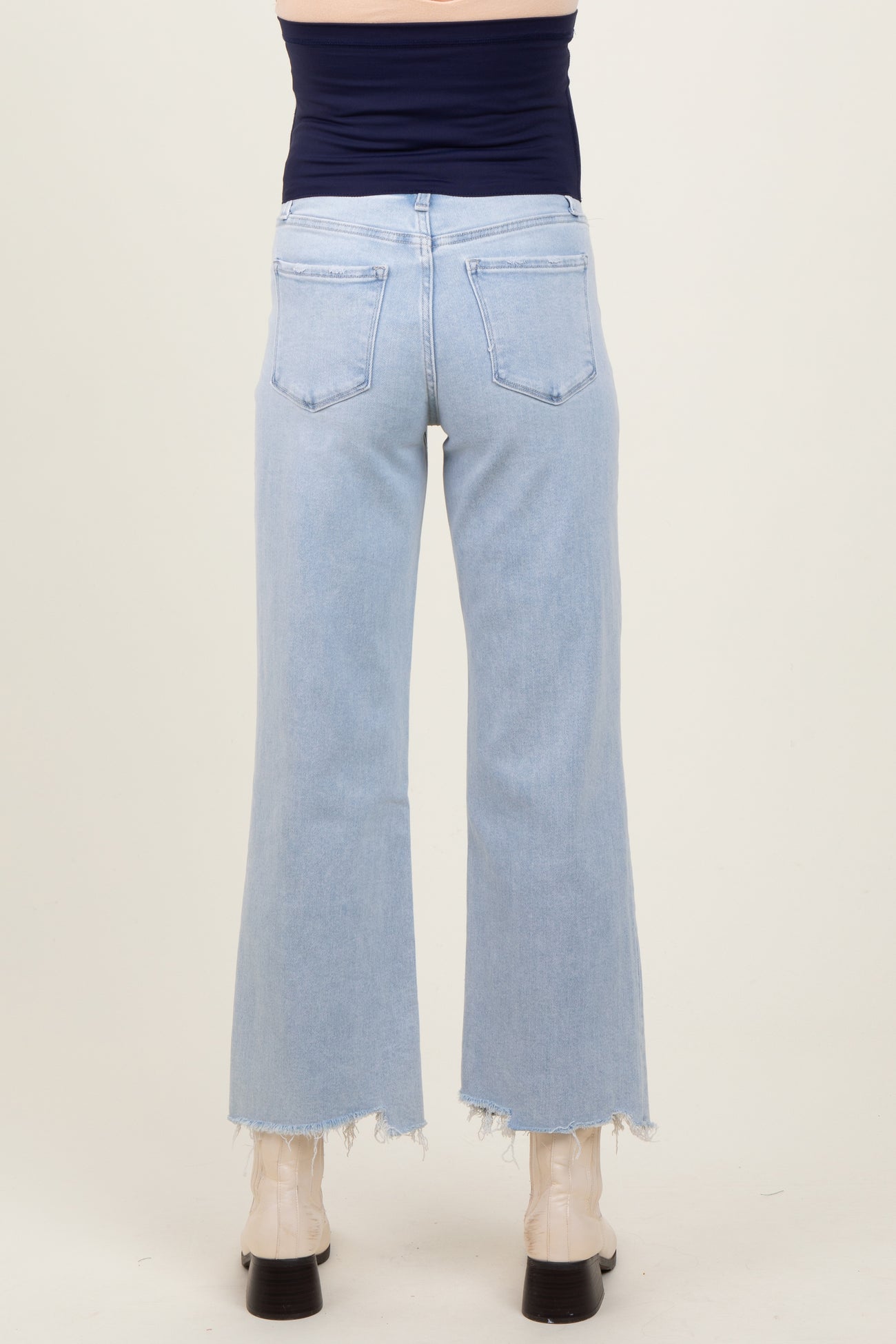 maternity wear light blue high-waisted flared jeans with frayed hems, shown from the back