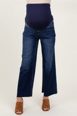 woman wearing a pair of dark blue wide-leg maternity jeans with a stretchy over-the-bump waistband and a visible baby bump