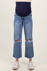 woman wearing a navy maternity belly band with distressed cropped jeans and white sneakers