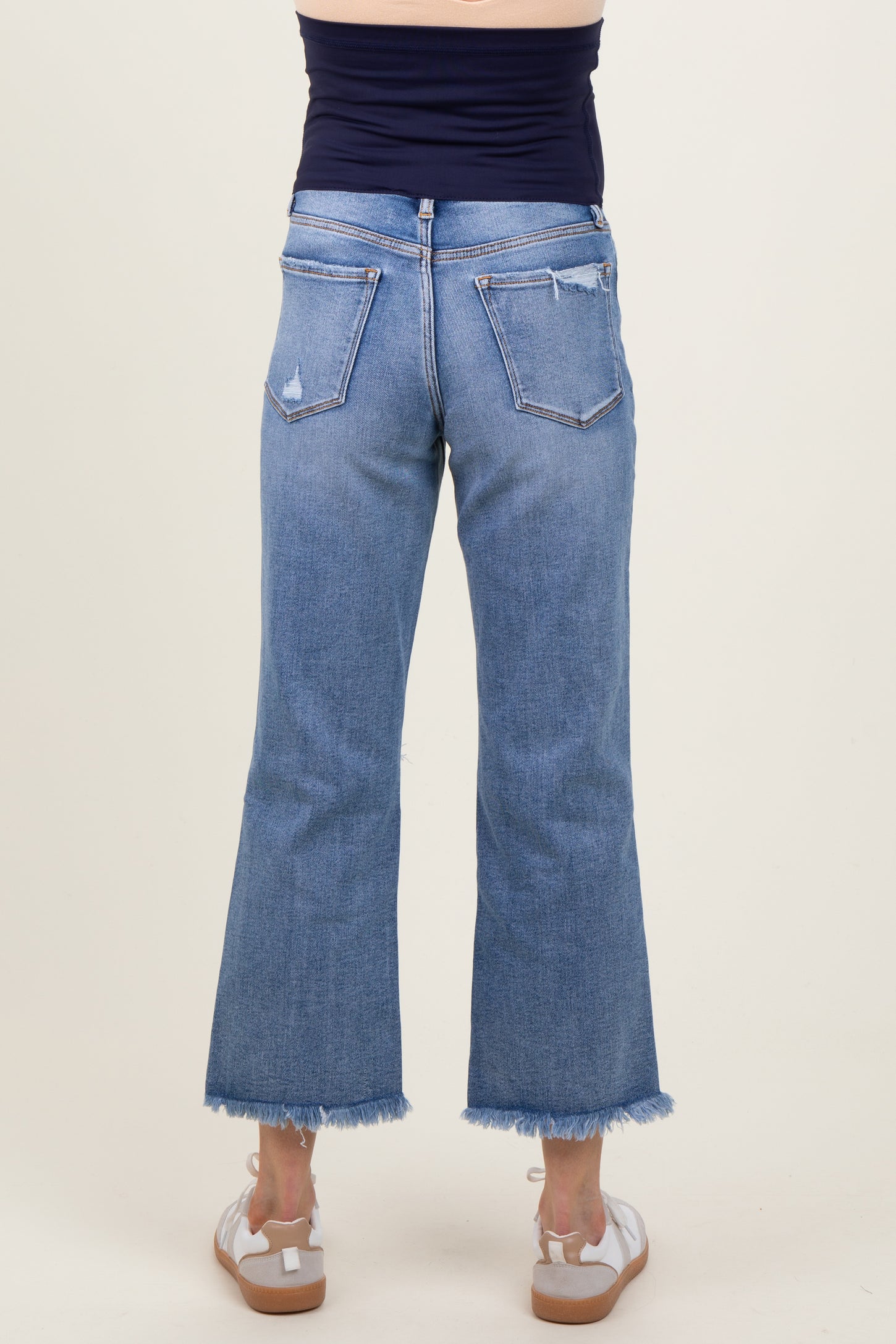 maternity wear light blue flared jeans with a frayed hem, model shown from the back