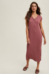 woman wearing a rust-colored ribbed midi dress with short sleeves and button details, standing against a neutral background