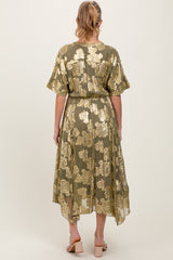 woman wearing a green floral maternity dress with gold detailing and a flowy hem, viewed from the back
