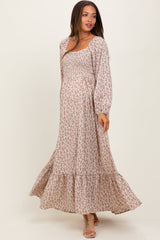 woman wearing a flowy floral print maternity maxi dress with long sleeves and a baby bump visible