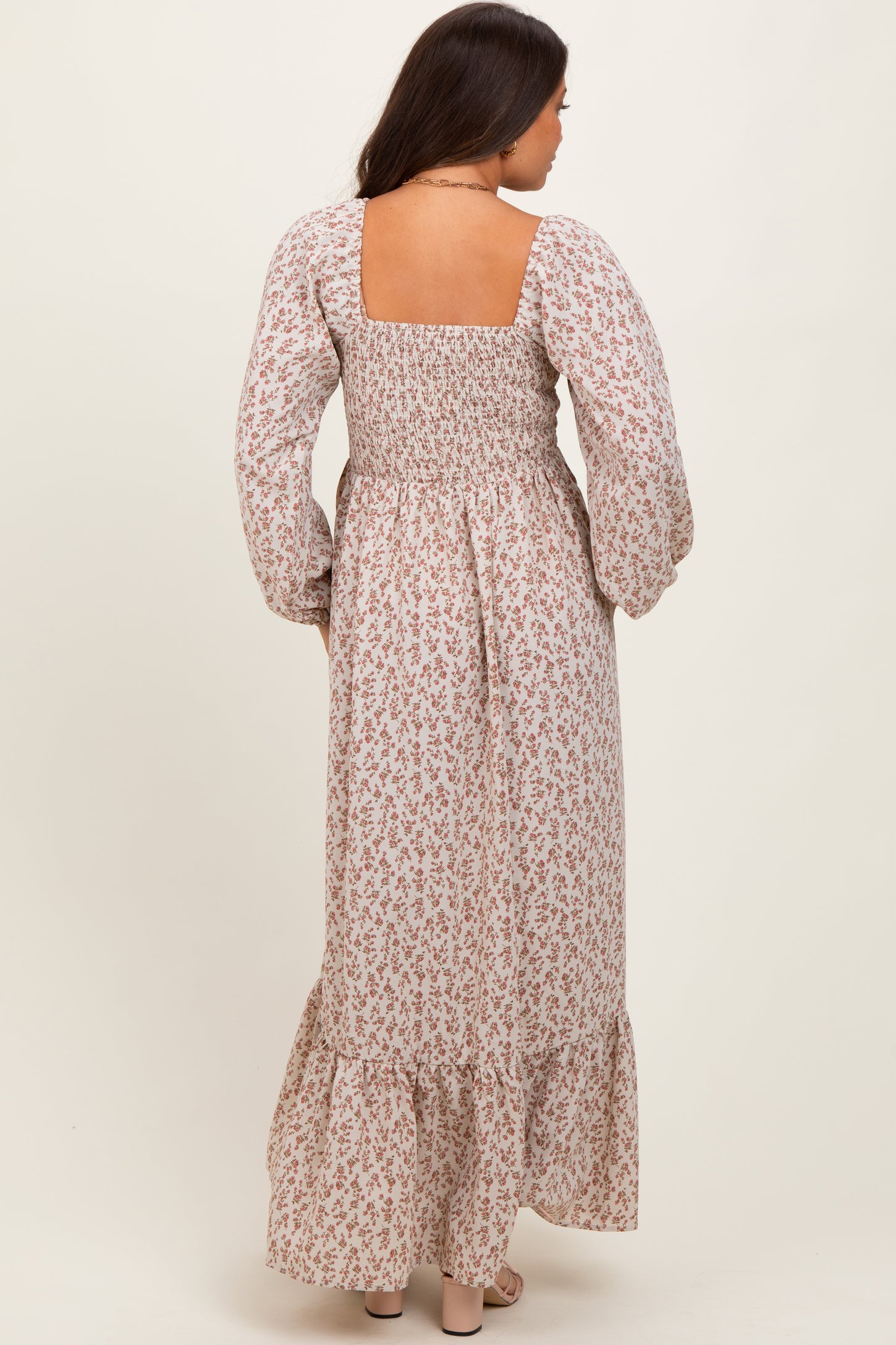 woman wearing a floral print maternity maxi dress with a smocked back and long sleeves