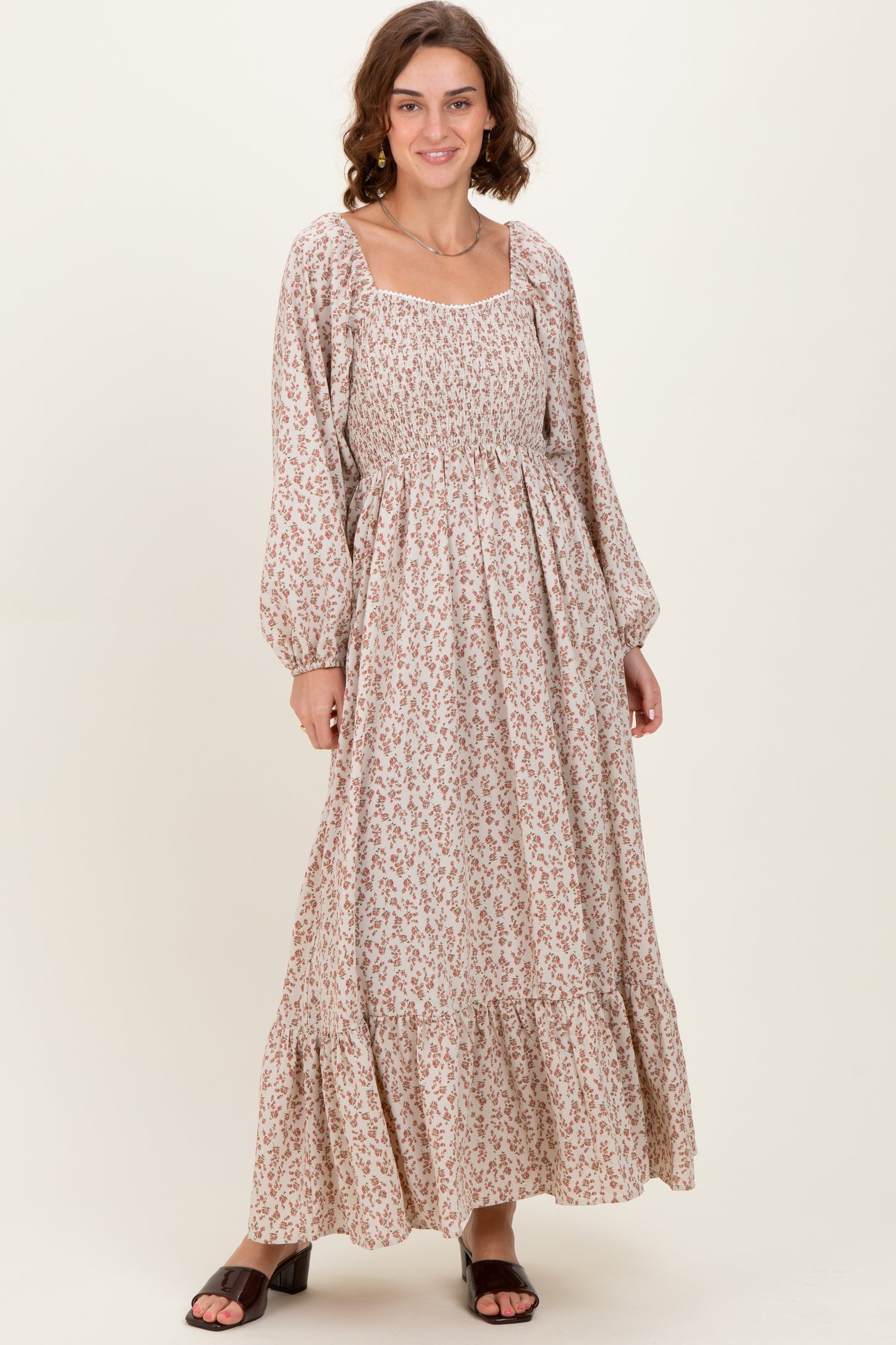 woman wearing a floral patterned long sleeve maxi dress with a square neckline and tiered hem