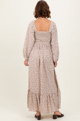 woman wearing a floral long sleeve maxi dress with a square back and gathered waist, shown from the back