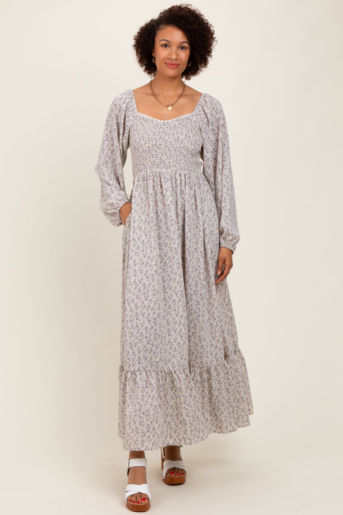 woman wearing a floral print long sleeve maxi dress with a square neckline and tiered skirt