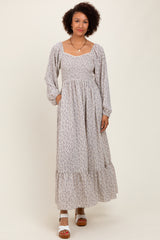 woman wearing a floral print long sleeve maxi dress with a square neckline and tiered skirt