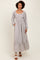 woman wearing a floral print long sleeve maxi dress with a square neckline and tiered skirt