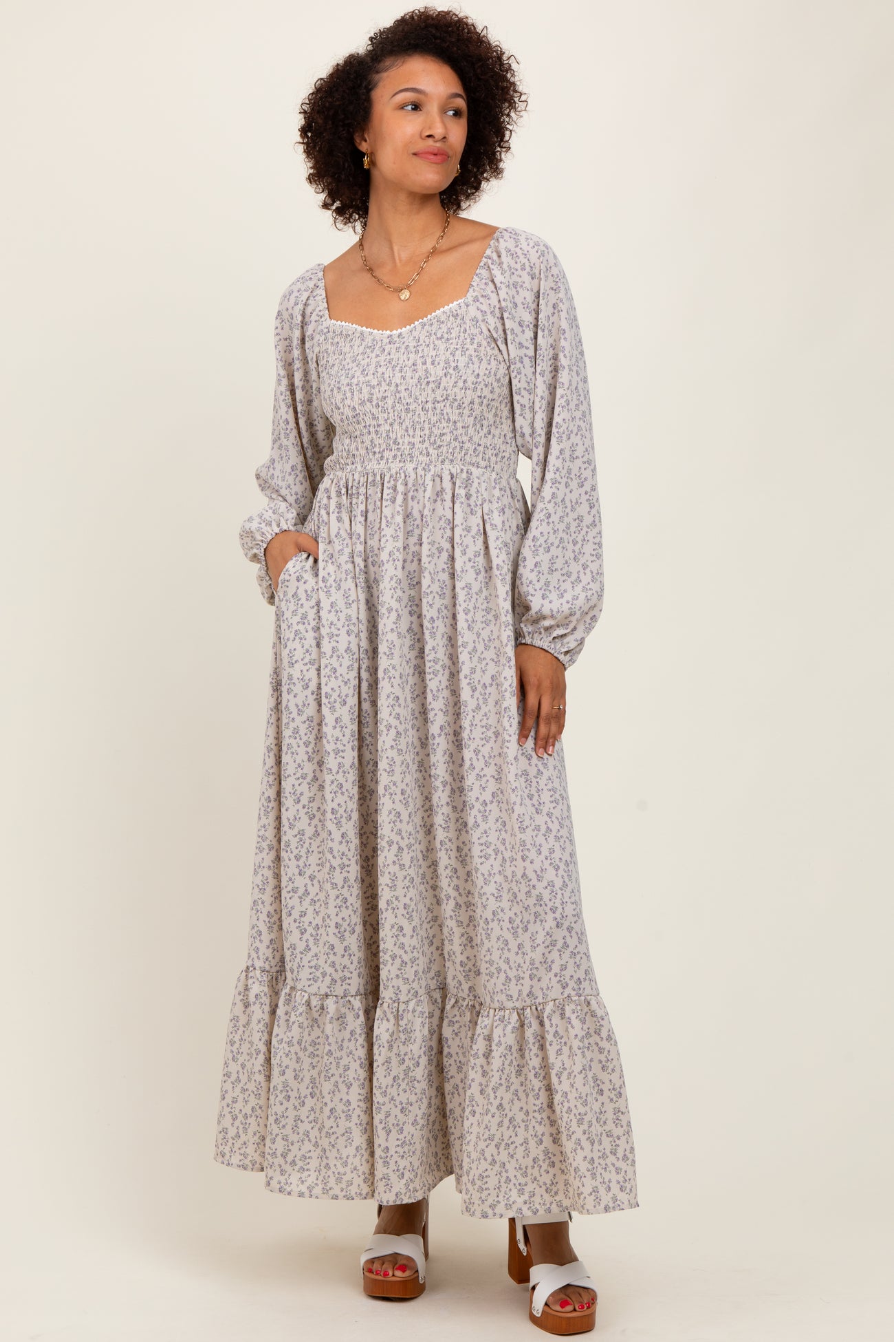 woman wearing a long sleeve floral print maxi dress with a square neckline and tiered ruffle hem